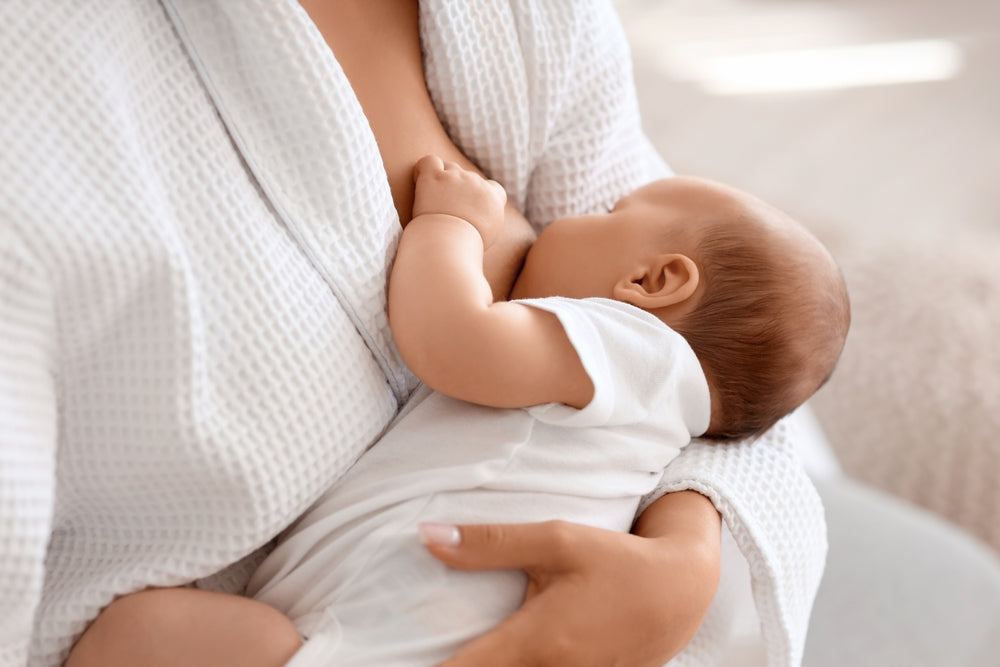 Baby breastfeeding in mother’s arms